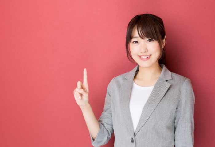 portrait of asian businesswoman pointing on red background